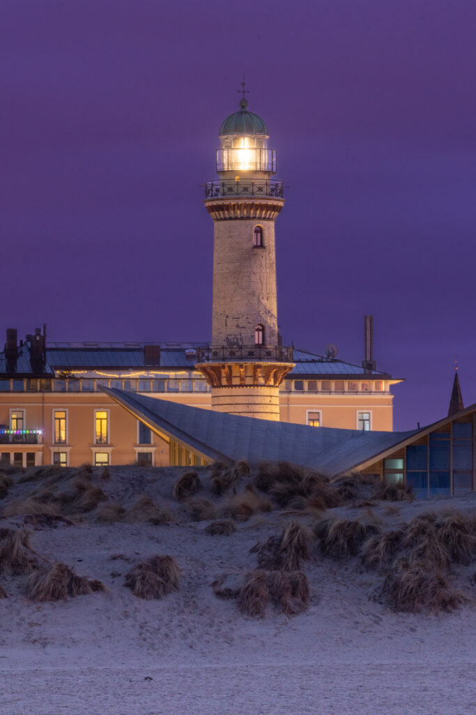 Der Warnemünder Leuchtturm bei Nacht mit Signallicht.